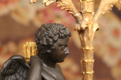 Paire de candélabres à trois lumières orné d'un Cupidon, bronze doré et patiné, XIXème siècle 