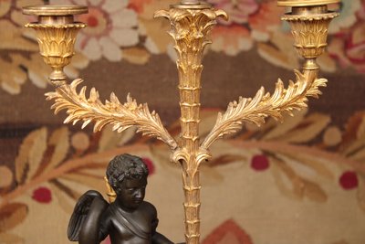 Paire de candélabres à trois lumières orné d'un Cupidon, bronze doré et patiné, XIXème siècle 