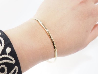 Bracciale rigido in oro giallo a metà