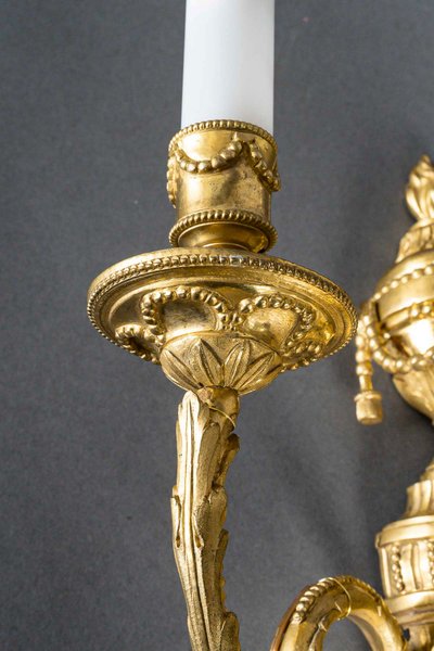 Coppia di applique in bronzo cesellato e dorato in stile Luigi XVI con due bracci, circa 1830-1850