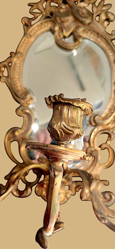 Pair of rococo style wall lights in gilded bronze and mirror