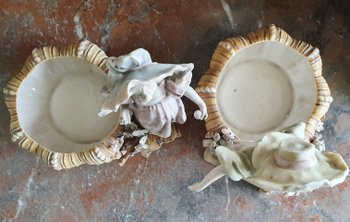 Bohemian-style porcelain figurines of children with shallow bowls, decorated with applique flowers dating to around 1900