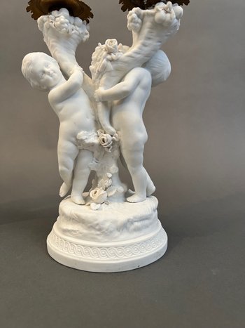 Pair of candlestick in cookie of Sevres with putti