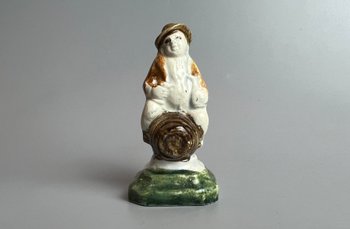 Eine c1790 Staffordshire pratt farbige Perlware-Topper-Figur, die auf einem Fass sitzt.