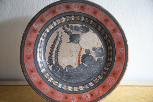 Large circular terracotta dish decorated with a fawn in a landscape.