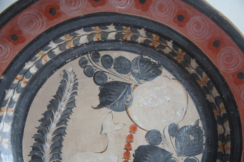 Large circular terracotta dish decorated with a fawn in a landscape.