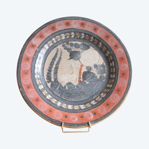 Large circular terracotta dish decorated with a fawn in a landscape.