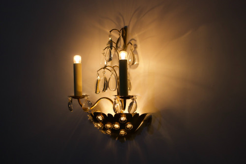 Brass floral sconce with pendants.