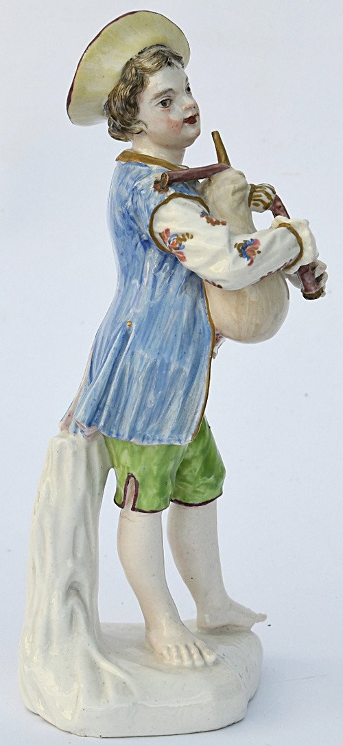 Porcelain statuette depicting a young boy playing the bagpipes