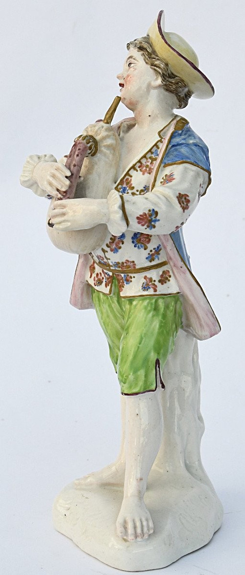 Porcelain statuette depicting a young boy playing the bagpipes