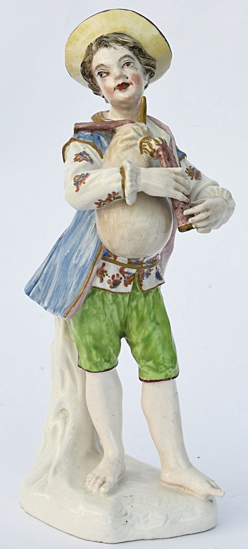 Porcelain statuette depicting a young boy playing the bagpipes