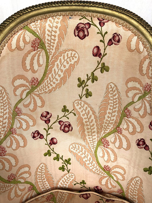 Paire de bergères en bois doré garnies de soie à motifs de fleurs, art déco d’inspiration Louis XVI