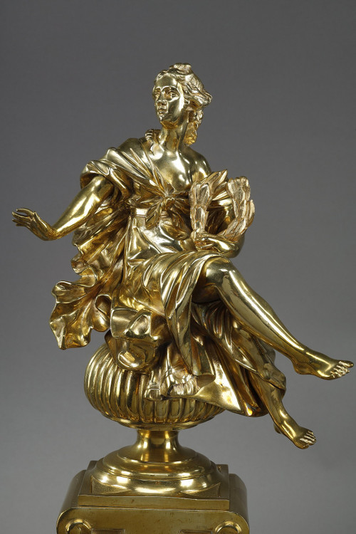 PAIR OF ORMOLU AND CHASED ANDIRONS DECORATED WITH SEATED MUSES