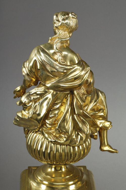 PAIR OF ORMOLU AND CHASED ANDIRONS DECORATED WITH SEATED MUSES