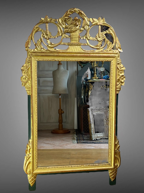 MIROIR EN BOIS SCULPTÉ DORÉ AVEC FRONTON AJOURÉ A DECOR DE FLEURS STYLE L.XVI