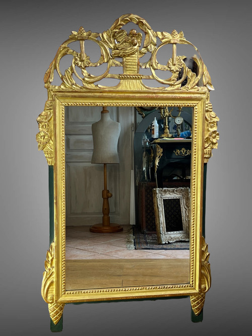 MIROIR EN BOIS SCULPTÉ DORÉ AVEC FRONTON AJOURÉ A DECOR DE FLEURS STYLE L.XVI