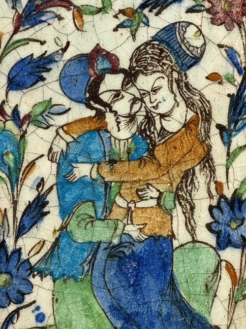 Enamelled tile representing an embracing couple in a stylized garden