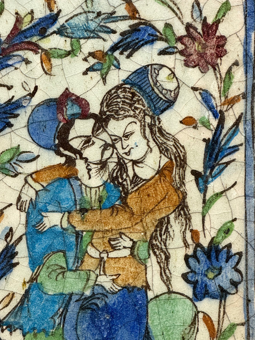 Enamelled tile representing an embracing couple in a stylized garden