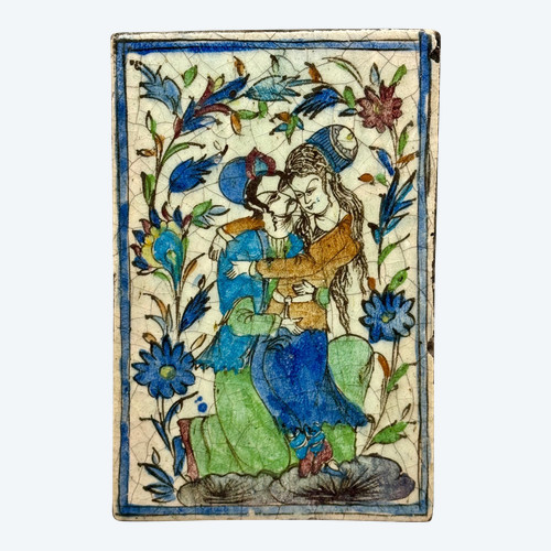 Enamelled tile representing an embracing couple in a stylized garden