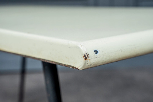 1960 coffee table with cream-colored top and designer tubular legs