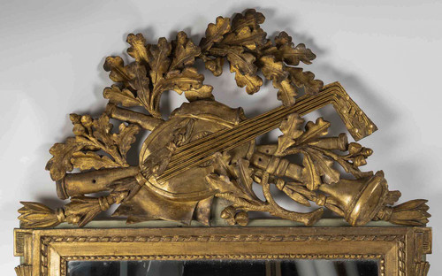 A large openwork pediment mirror in carved and gilded wood with musical attributes from the Louis XV