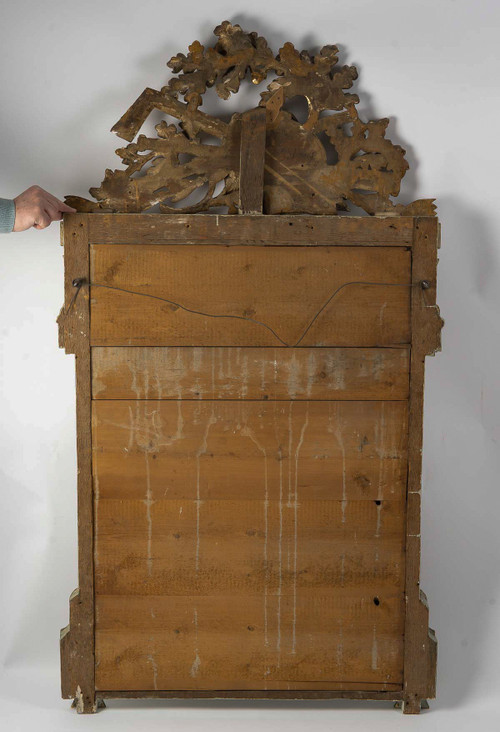 A large openwork pediment mirror in carved and gilded wood with musical attributes from the Louis XV