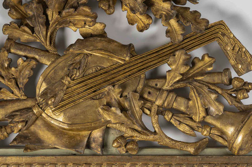 A large openwork pediment mirror in carved and gilded wood with musical attributes from the Louis XV