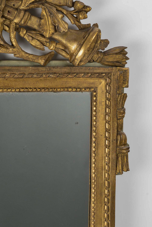 A large openwork pediment mirror in carved and gilded wood with musical attributes from the Louis XV