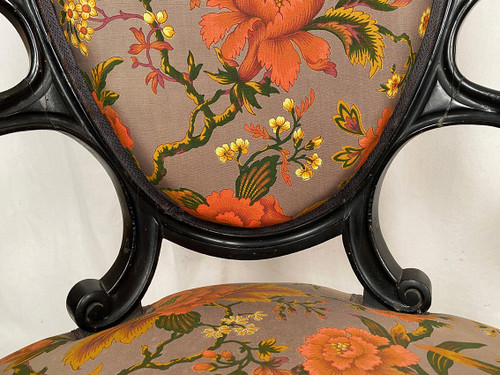 Paire de fauteuils Napoléon III, en bois noirci, garnis de tissu à motif floral