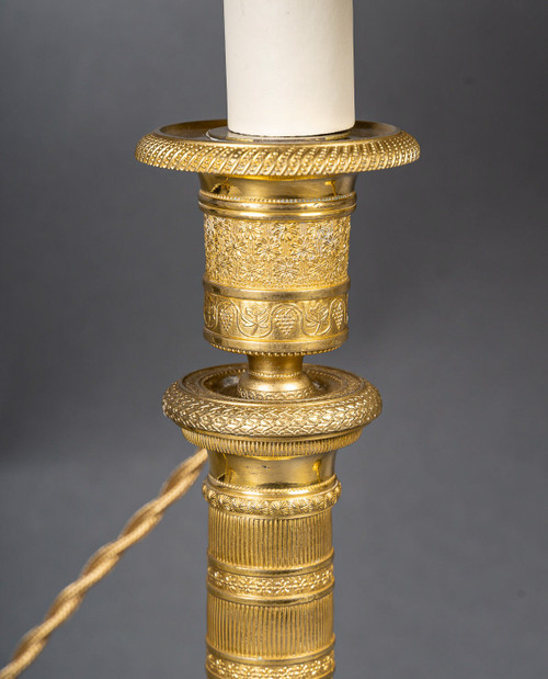 Coppia di candelieri in bronzo dorato e finemente cesellato di epoca Impero, montati come lampade, 1810 ca.