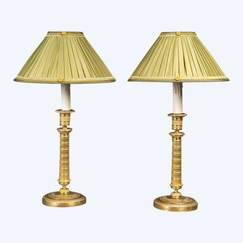 Coppia di candelieri in bronzo dorato e finemente cesellato di epoca Impero, montati come lampade, 1810 ca.