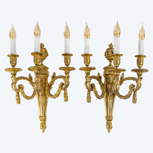 A large pair of Louis XVI ormolu sconces with rams, circa 1820-1830