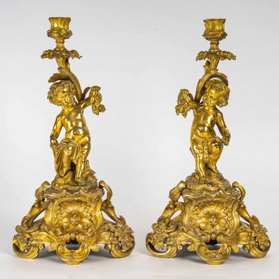 A pair of Napoleon III period gilt bronze Putti candlesticks, mounted as lamps