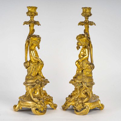 A pair of Napoleon III period gilt bronze Putti candlesticks, mounted as lamps