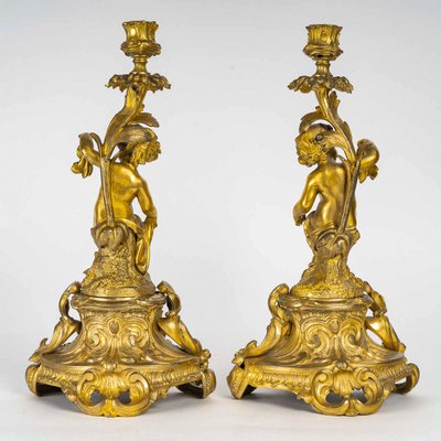 A pair of Napoleon III period gilt bronze Putti candlesticks, mounted as lamps