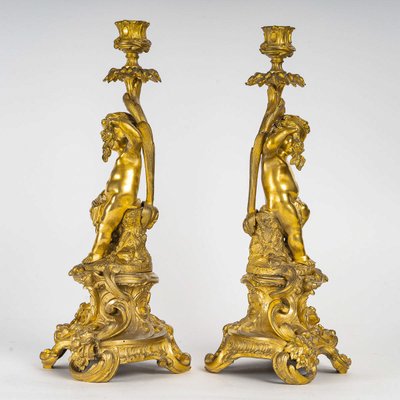 A pair of Napoleon III period gilt bronze Putti candlesticks, mounted as lamps