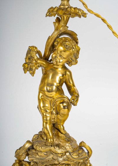 A pair of Napoleon III period gilt bronze Putti candlesticks, mounted as lamps