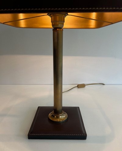 Lampada da tavolo in pelle marrone e ottone. Opera francese nello stile di Jacques Adnet