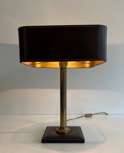 Lampada da tavolo in pelle marrone e ottone. Opera francese nello stile di Jacques Adnet