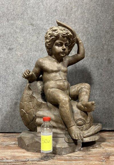 Italy, circa 1900: monumental marble statue of a Putto or cherub straddling a dolphin