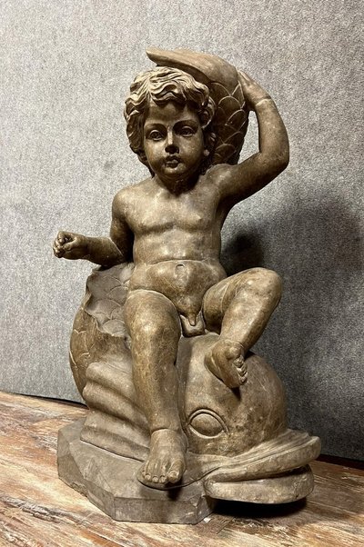 Italy, circa 1900: monumental marble statue of a Putto or cherub straddling a dolphin