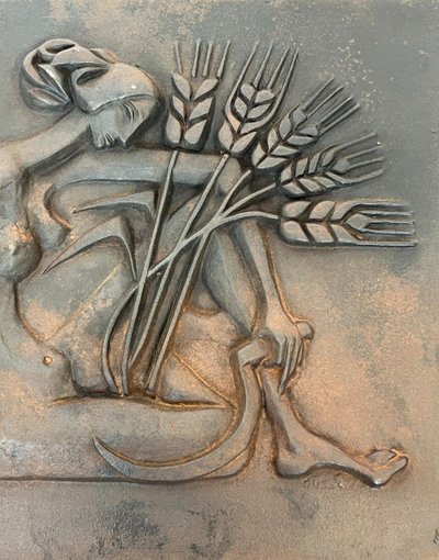 Modernist cast-iron plaque depicting a Nude Woman Holding a Scythe and Wheat Spikes.