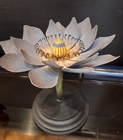 Painted metal water lily mounted on a wooden base