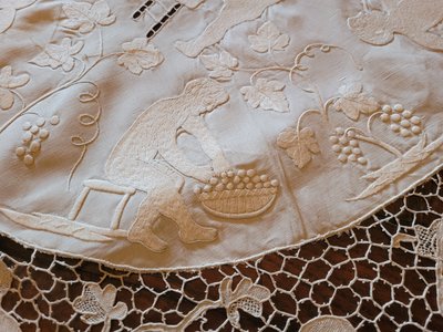 Embroidered pedestal tablecloth on the theme of grape harvests and wine, circa 1900