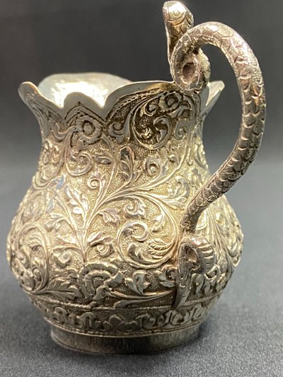 Milk jug in richly chased solid silver with Indo-Persian design and cobra handle