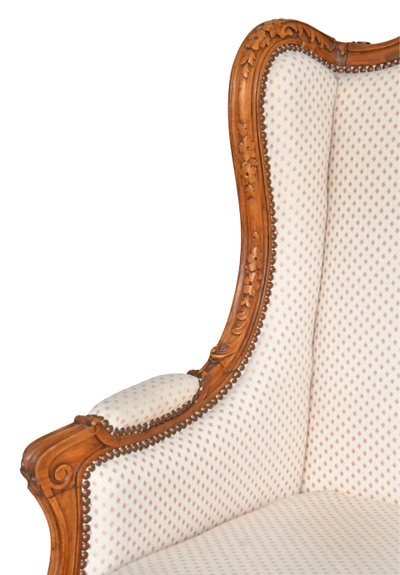 Louis XV style wing chair in richly carved wood