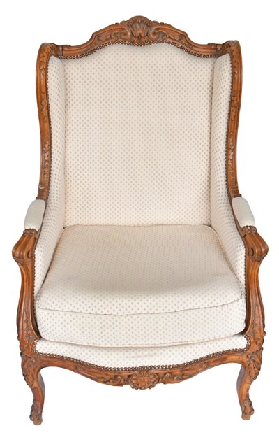 Louis XV style wing chair in richly carved wood