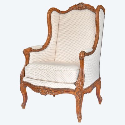 Louis XV style wing chair in richly carved wood