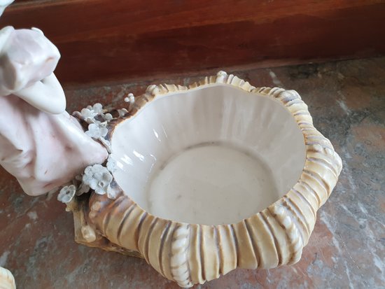 Bohemian-style porcelain figurines of children with shallow bowls, decorated with applique flowers dating to around 1900