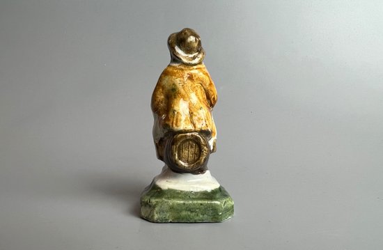 Eine c1790 Staffordshire pratt farbige Perlware-Topper-Figur, die auf einem Fass sitzt.